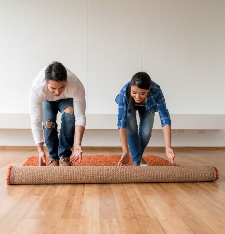 Two people rolling out a carpet 